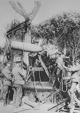 Gunners Lowering A Howitzer Shell Into Position On The Western Front
