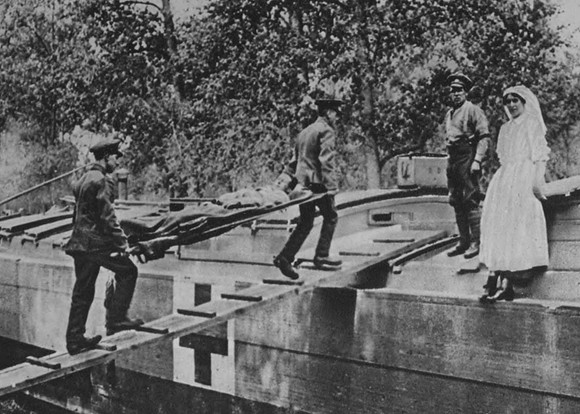 Wounded British Soldier Being Carried Onto A Red Cross Barge Behind  The Lines In France
