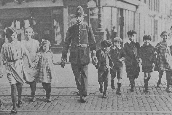 A Police Officer Crossing The Road With Children London 1920s