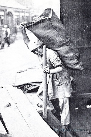 A Woman Gas Worker Carrying A Hundredweight Sack Of Coke
