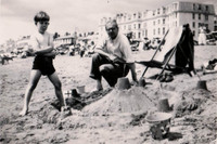 A  Little Boys Proud Of His Sandcastle
