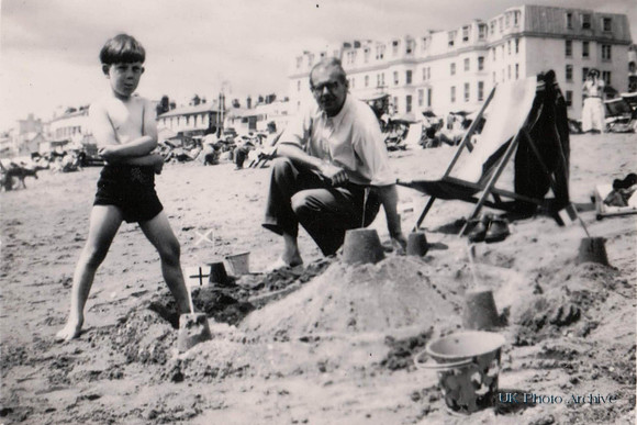 A  Little Boys Proud Of His Sandcastle