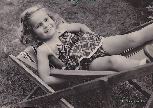 A Little Girl Sitting Upside Down In A Deckchair