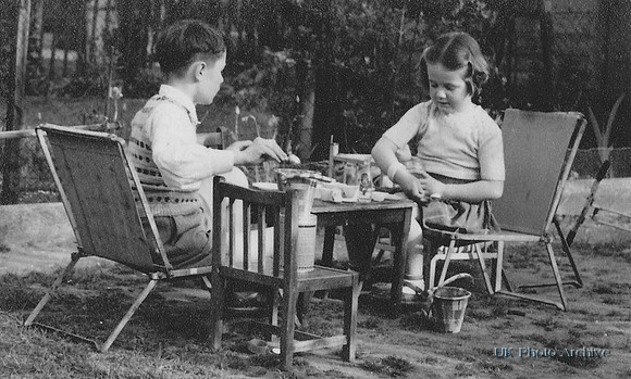 Children Called David And Hazel Playing At A Table In The Garden 1950s