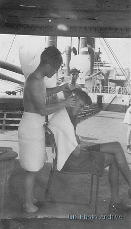 Ken Rogers Having His Hair Cut Aboard SS Explorer 1947