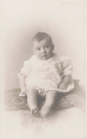 A Baby Sitting On A Cushion c.1910