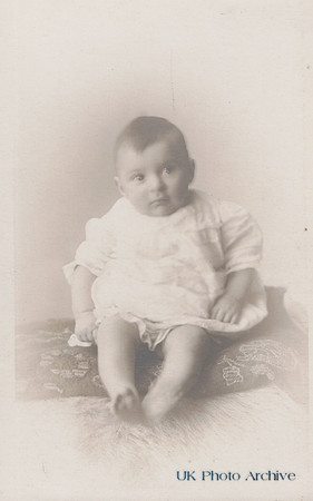A Baby Sitting On A Cushion c.1910