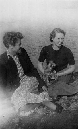 Two Women Sitting Relaxing With A Yorkshire Terrier